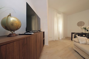 Ein Wohnzimmer mit einer Holzeinrichtungsanlage, einem Flachbildfernseher, einem Globus und einem Sofa.