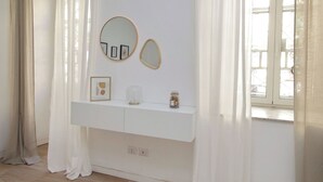 A white vanity with two mirrors, a framed picture, and a jar with corks. - Amiterno Elegance - by Domus & Dimore (Rome)