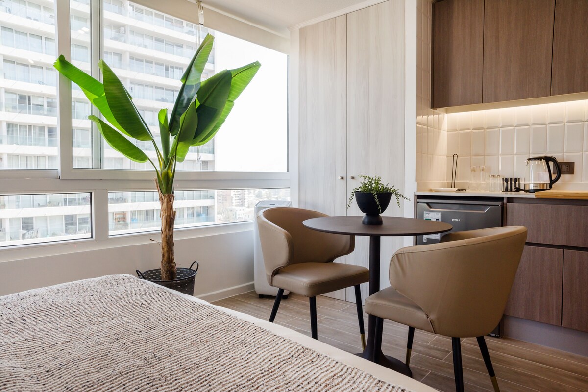 Eine moderne Küche mit Essbereich, einem Blumentopf und Blick auf die Stadt.