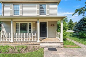 A two-story house with a front porch, a mailbox, and a street sign. - La Dolce Vita | Walk to Downtown NOTL (10 minutes) (Niagara-on-the-Lake)