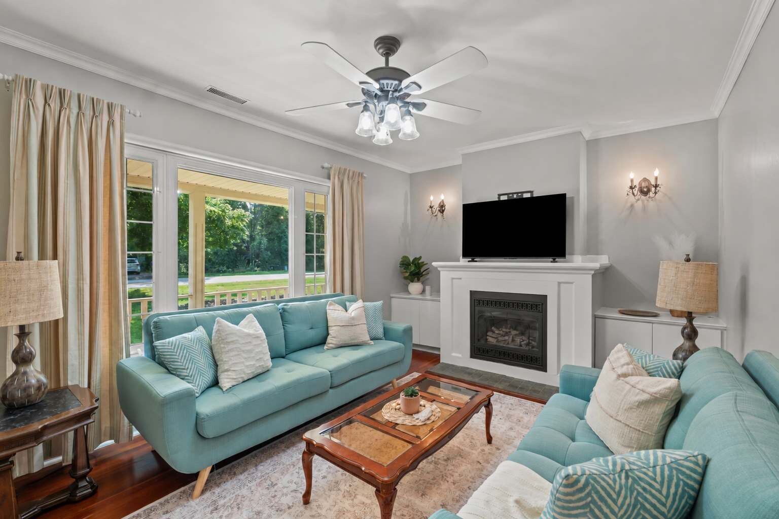A living room with a sofa, a coffee table, a fireplace, and a television.