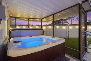 A hot tub with a wooden exterior, surrounded by a covered patio area with a view of a backyard. - Pickleball, Hot Tub, Pool, Mini Golf, Arcades, Billiards, and More! (St. Petersburg)