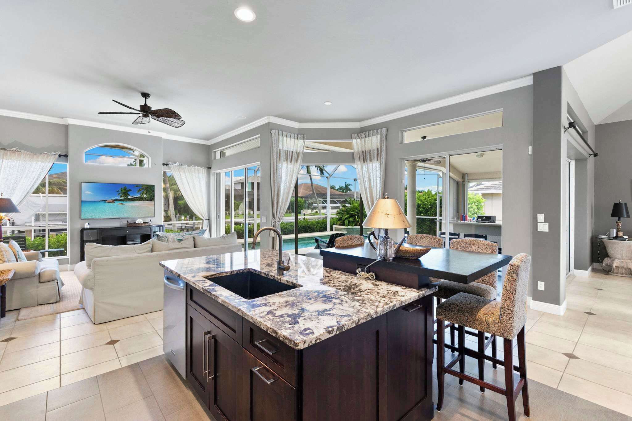 A spacious living area with a large island, a dining table, and a seating arrangement.