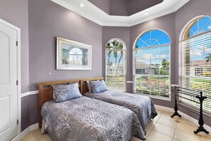 A bedroom with two beds, a large window with blinds, and a framed picture on the wall. - Waterfront Retreat - Private Pool - Large Dock (Marco Island)