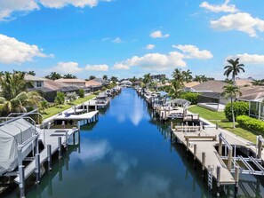 Un port de plaisance avec des quais, des bateaux et des maisons le long d’un canal.