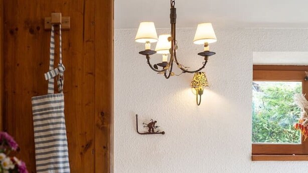 Puisesta materiaalista valmistettu ruokailutila, jossa on pöytä, tuolit ja kattokruunu.