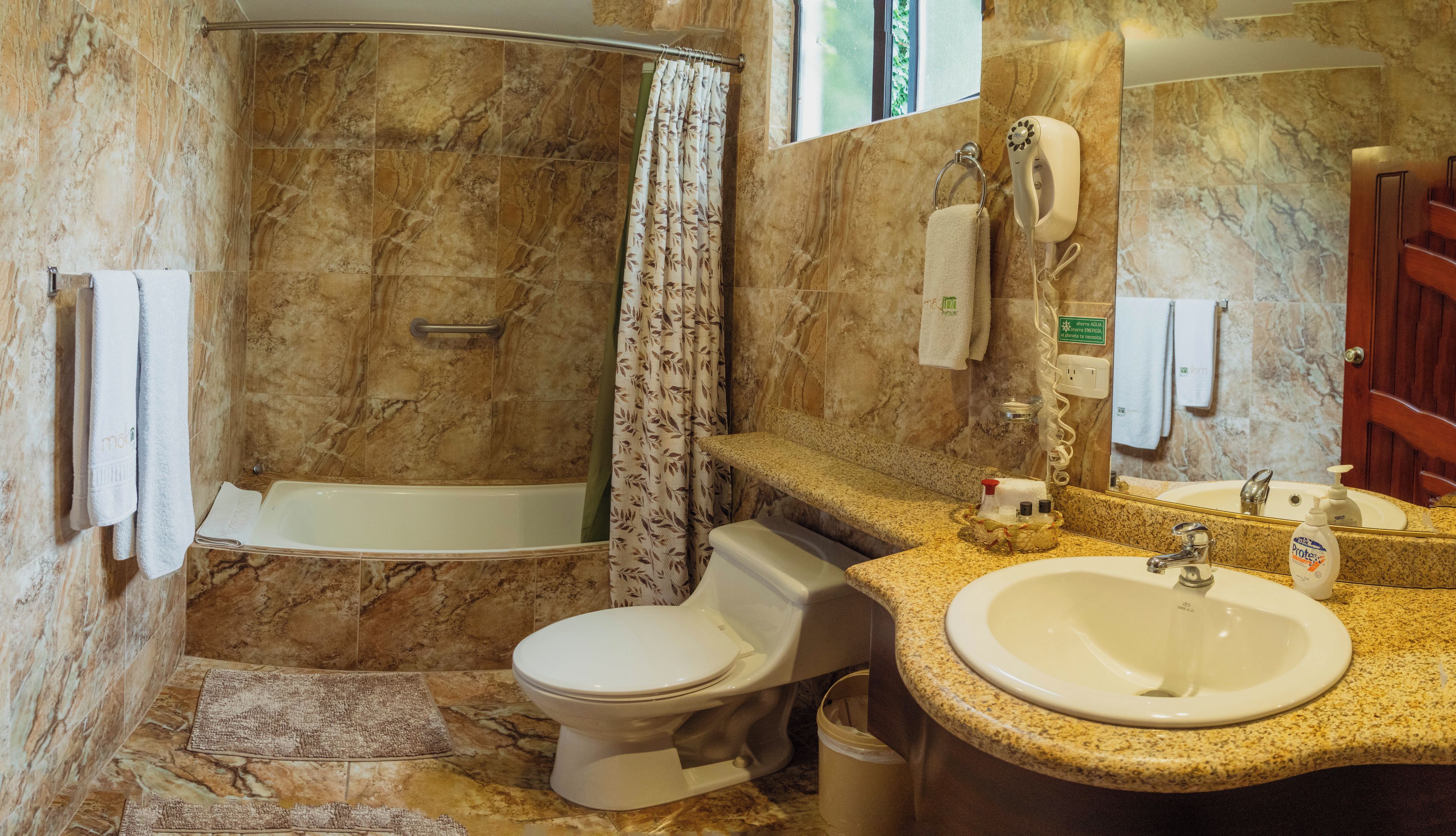 Une salle de bain avec une baignoire, des toilettes et un lavabo.
