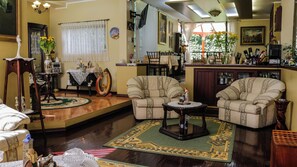 A cozy living room with two armchairs, a coffee table, and a dining area with a table and chairs.