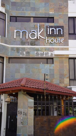 A building with a sign reading 'Mak Inn House' and a number '5936' on the facade.