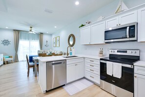 A modern kitchen with white cabinetry, a built-in microwave, and a stove. - Steps to Dock & Sand! Waterfront Hudson Retreat (Hudson)