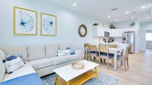 A modern living room with a sofa, coffee table, and dining area. - Waterfront Duplex with boat dock (Hudson)