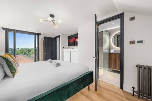 Ein Schlafzimmer mit Bett, Fernseher und einem Badezimmer mit Dusche.