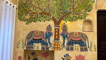 A wall mural with a tree, elephants, and birds.