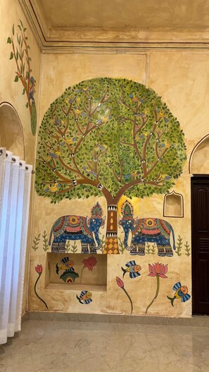 A wall mural with a tree, elephants, and birds.