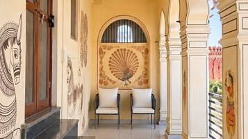 A corridor with a ceiling fan, a mural, and a staircase leading to an upper level.