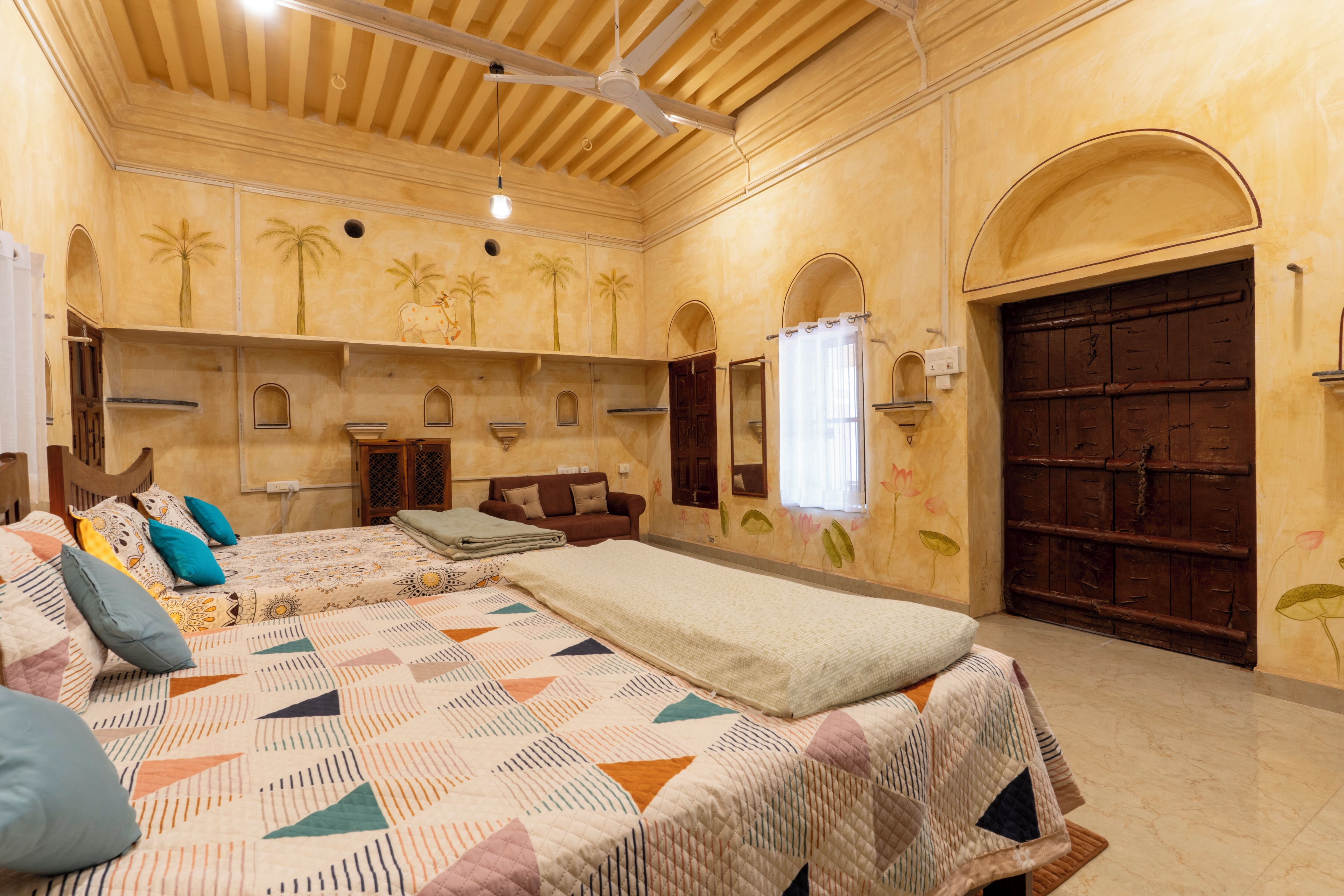 Una habitación con una cama grande, un armario de madera, una ventana con cortinas y una puerta.