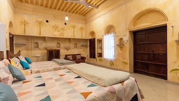 Una habitación con una cama grande, un armario de madera, una ventana con cortinas y una puerta.