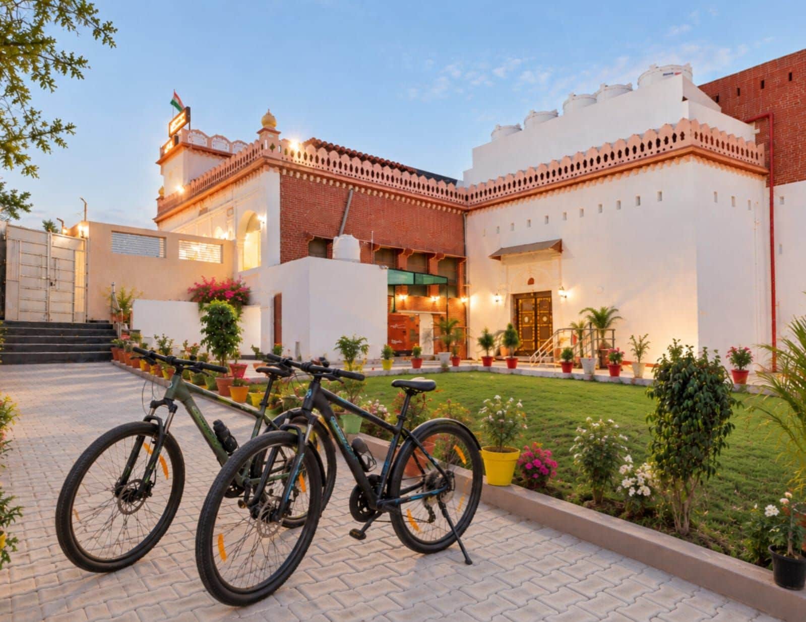 A building with a large entrance, a flag, and a bicycle parked in front.