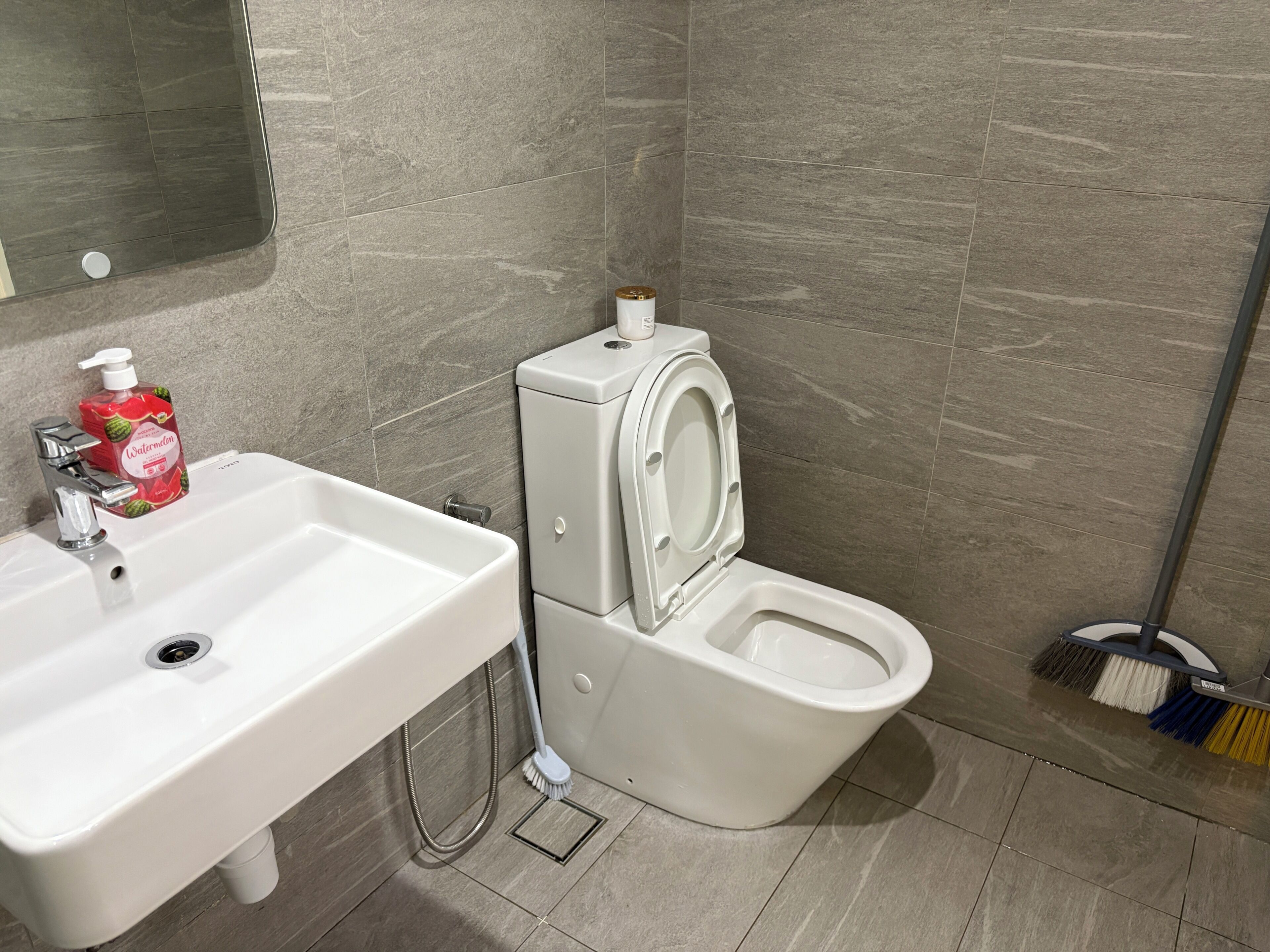 Un baño con lavamanos, inodoro y ducha blancos.