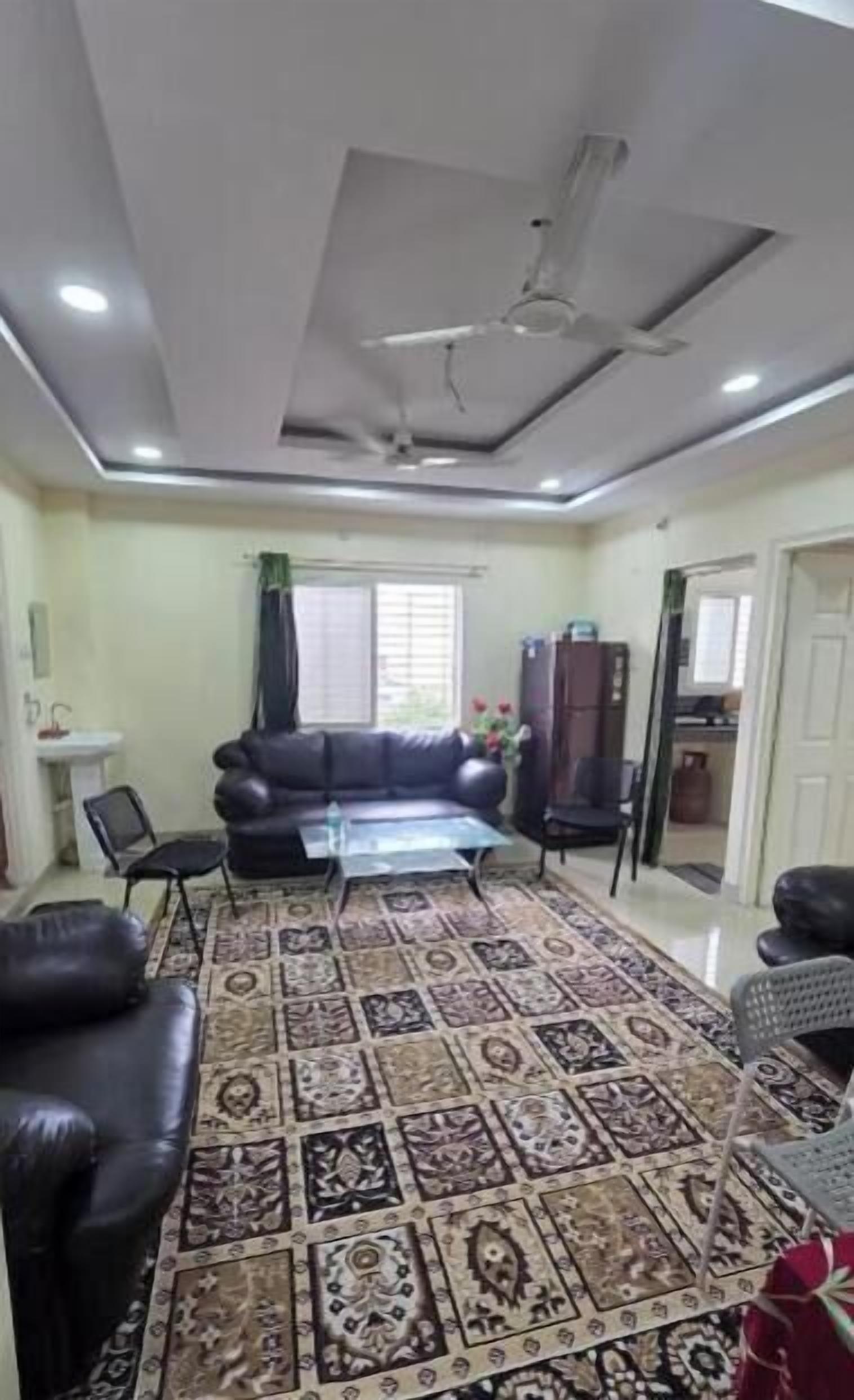 A living room with a sofa, a coffee table, and a patterned rug.