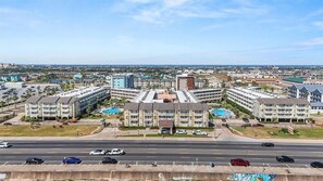 Aerial view of resort-style condos with pools near the beach - Ocean Front Condo - 2 pools hot tub Cruise Parking on seawall babes beach (Galveston)