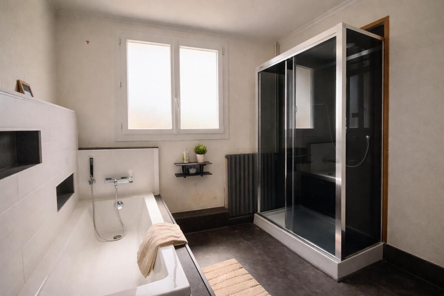 Un bagno moderno con vasca, doccia e cabina doccia in vetro.