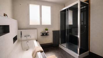 Un bagno moderno con vasca, doccia e cabina doccia in vetro.