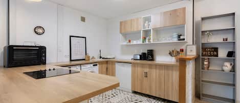 Una cocina moderna con armarios de madera, horno empotrado y una isla central.