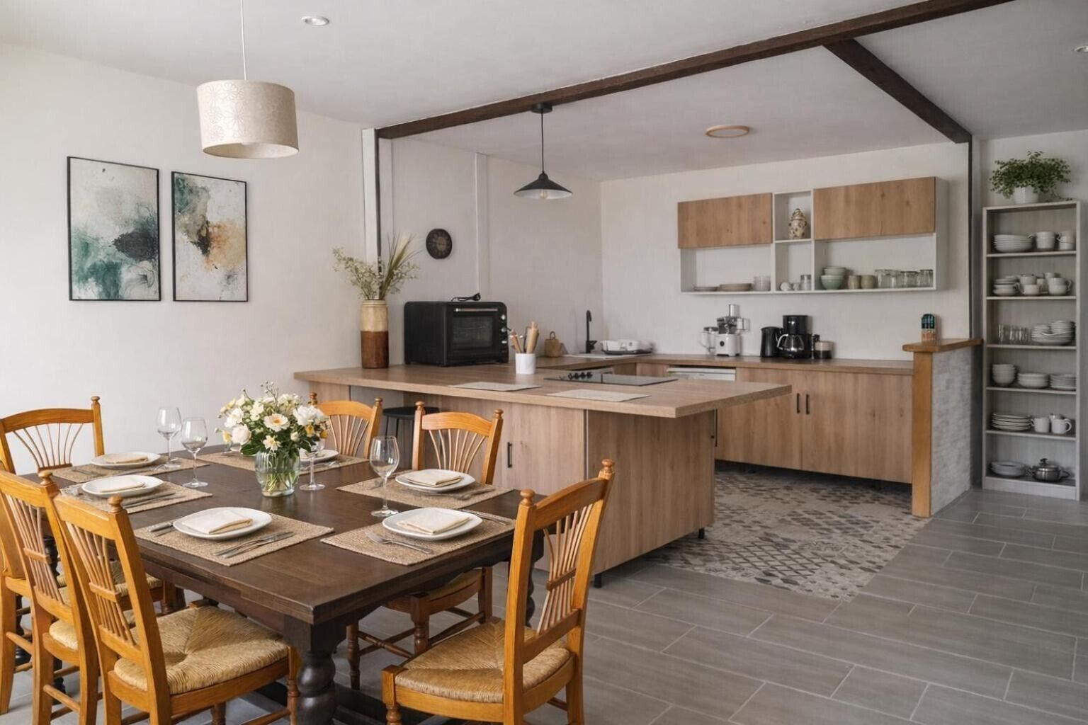 Una cucina moderna con mobili in legno, un'isola centrale e un'area pranzo con sedie e tavolo imbanditi per quattro persone.
