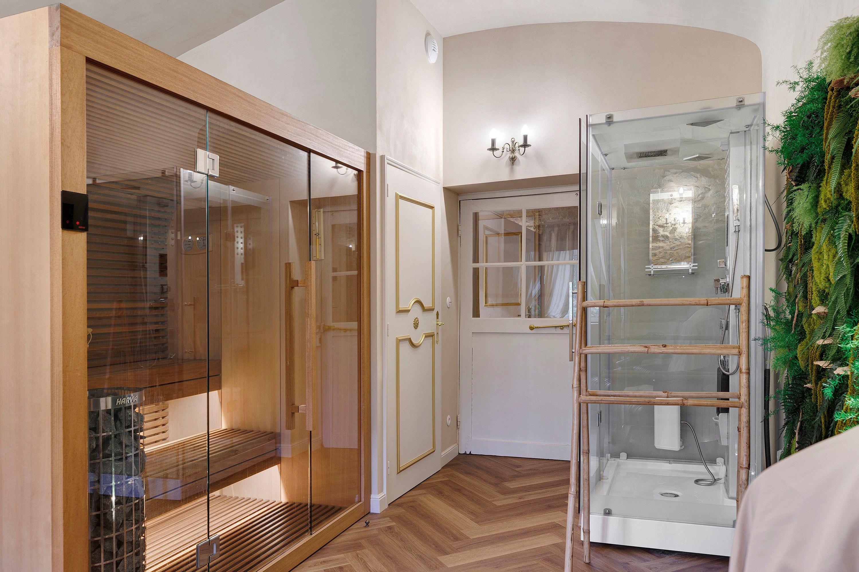 Una habitación con un armario de madera, cabina de ducha de vidrio y una puerta con panel de cristal.