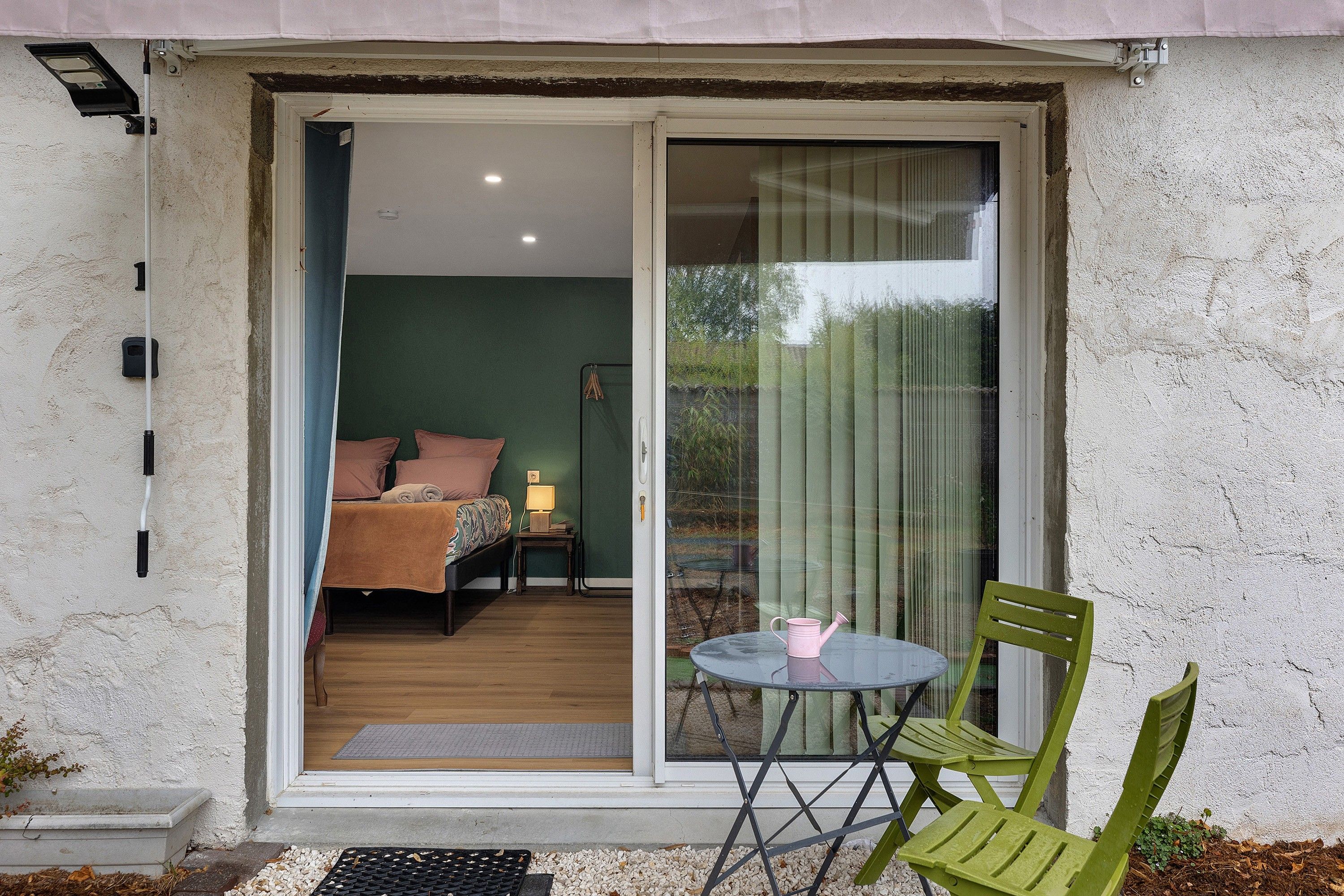 A room with a bed, a small table, and a chair.