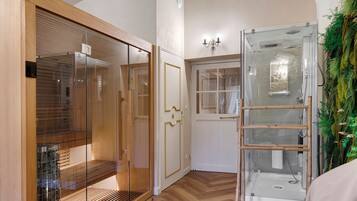 A room with a wooden wardrobe, a glass shower enclosure, and a door with a glass panel.