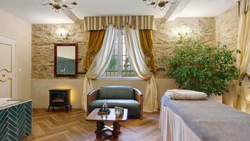 A cozy room with a fireplace, a sofa, a table with a candle, and a plant.
