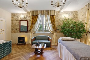A cozy room with a fireplace, a sofa, a table with a candle, and a plant. - Relai du Château - Canopé PMR Studio (Chemillé-en-Anjou)