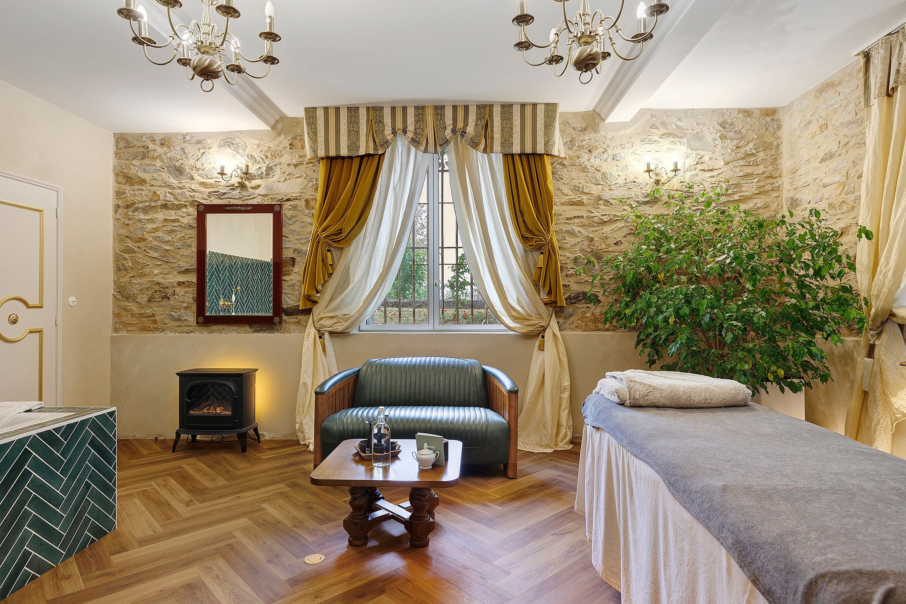A cozy room with a fireplace, a sofa, a table with a candle, and a plant.