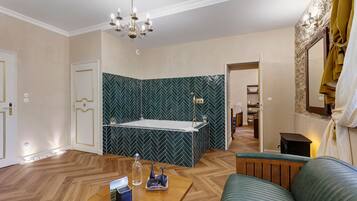 Et stilfuldt badeværelse med et fristående badekar, en bruseniche og et toiletbord.