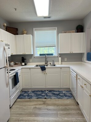A kitchen with white cabinets, a built-in oven, a microwave, and a sink. - Golf and Beach Condo!! Sleeps 8! Labor Day Special! Resort amenities! (North Myrtle Beach)