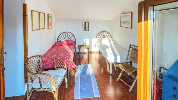 Ein Zimmer mit zwei Betten, einem kleinen Tisch und einem Stuhl.