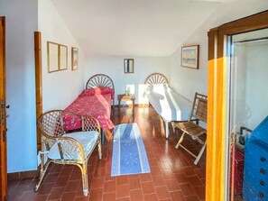 Ein Zimmer mit zwei Betten, einem kleinen Tisch und Stühlen.