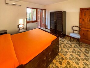 A bedroom with a bed, a wardrobe, a chair, and a window. - Villa Carra - Ansedonia (Ansedonia)
