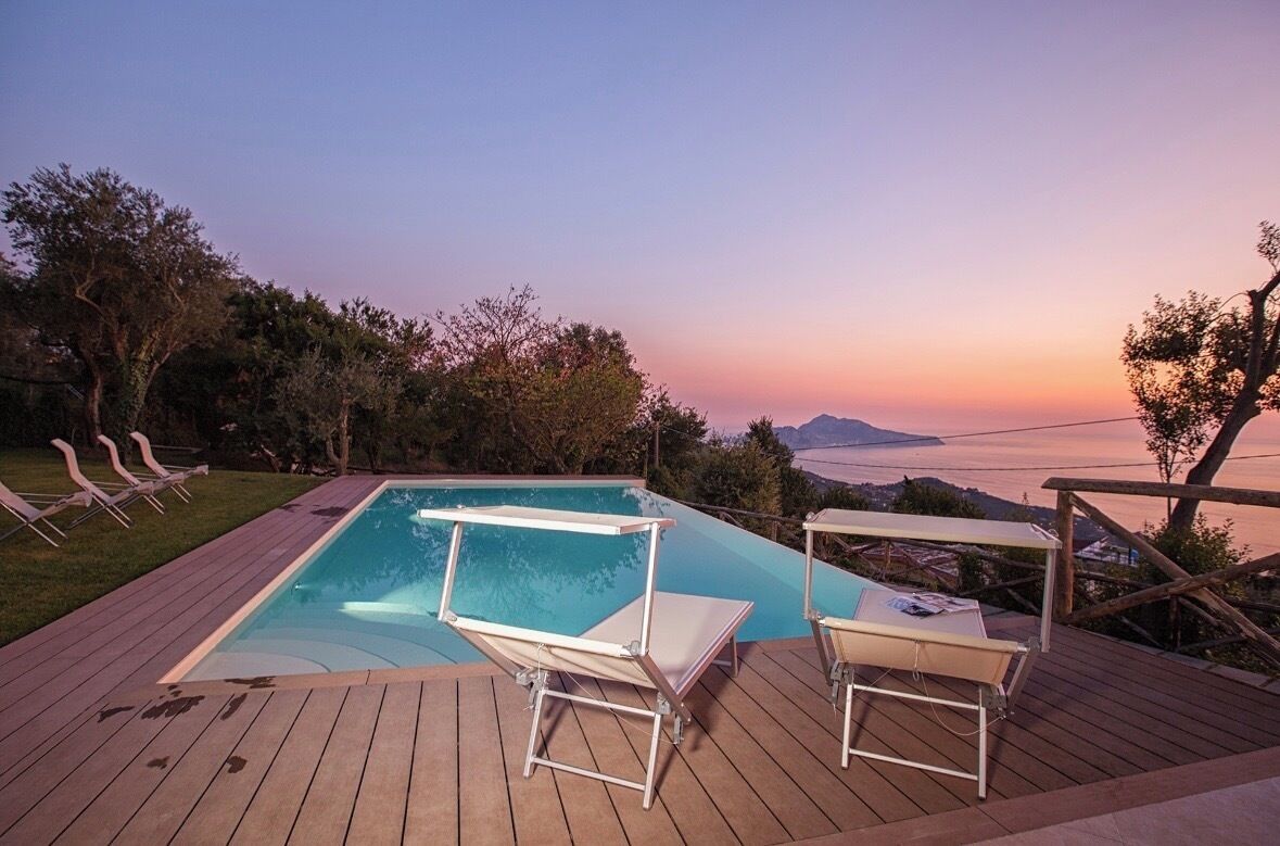Ein Pool mit Liegestühlen und einer Sonnenterrasse mit Blick auf eine schöne Aussicht.