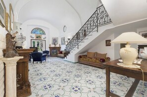 A spacious room with a staircase, a fireplace, and a dining area with a table and chairs.