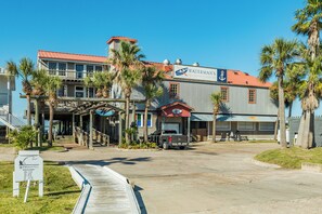 Ein Gebäude am Wasser mit rotem Dach, einem Schild für 'Waterman's Restaurant' und einem Steg, der ins Wasser führt.