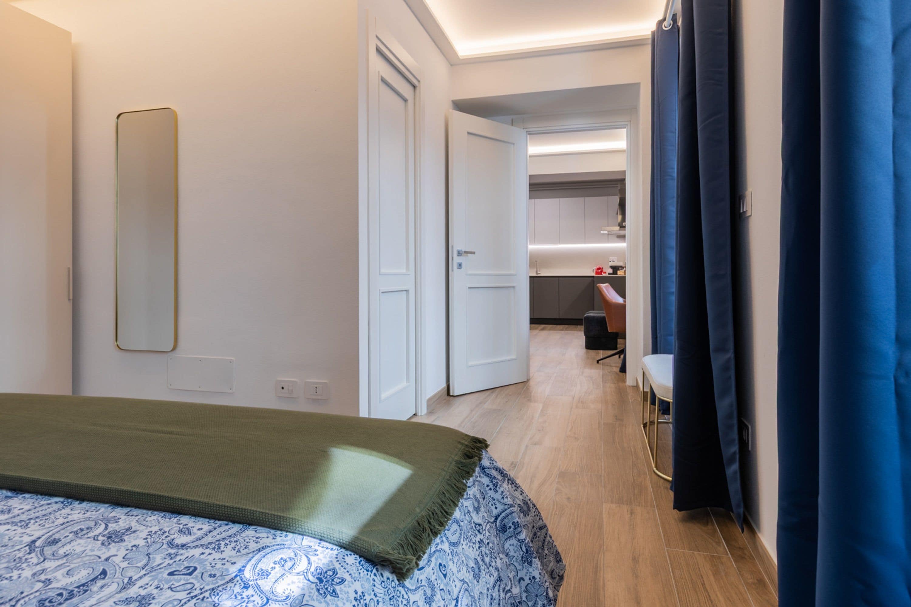 Une chambre d’hôtel avec un lit, un miroir, un bureau et une chaise.