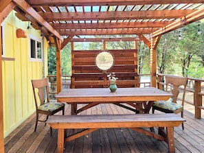 A wooden deck with a table and benches, surrounded by a wooden pergola. - Sunshine Cabin - Peaceful Retreat in The Redwoods (Garberville)
