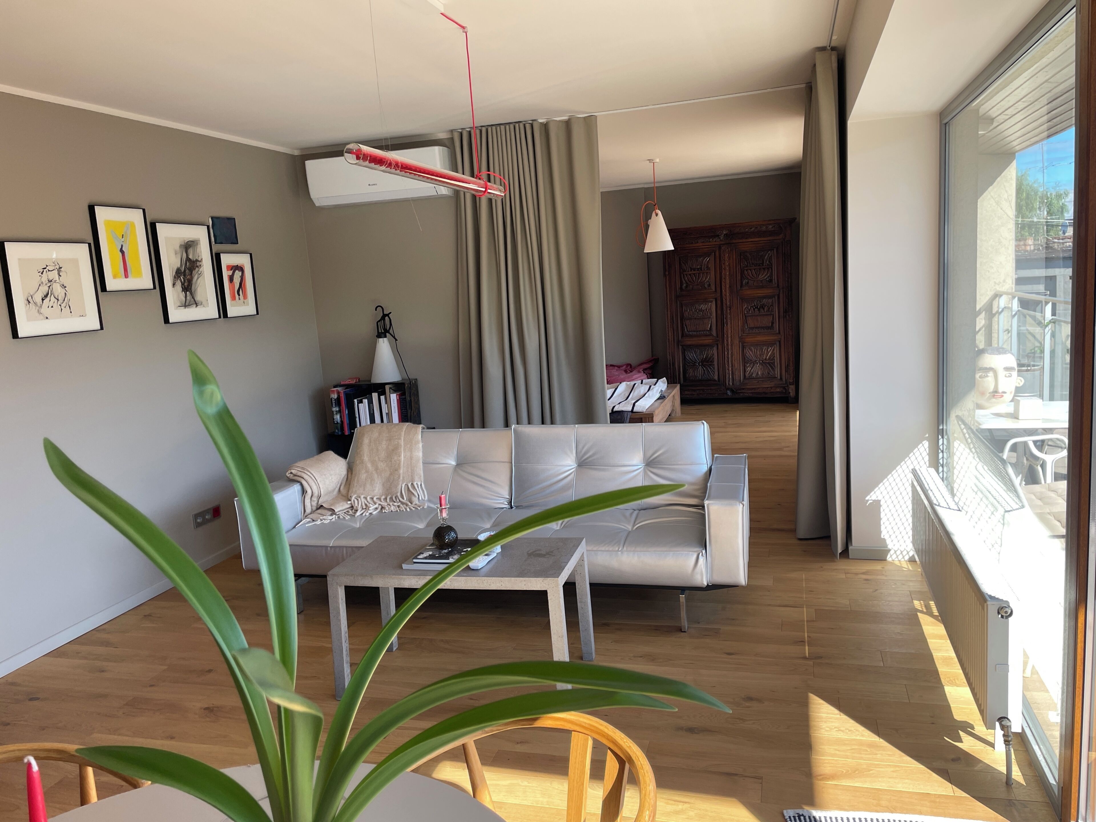 Een moderne woonkamer met een bank, salontafel en een groot raam.