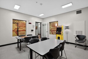 A conference room with a chessboard, chairs, tables, a clock, and a vending machine. - Modern King Suite - Steps from UAT and near ASU (Tempe)