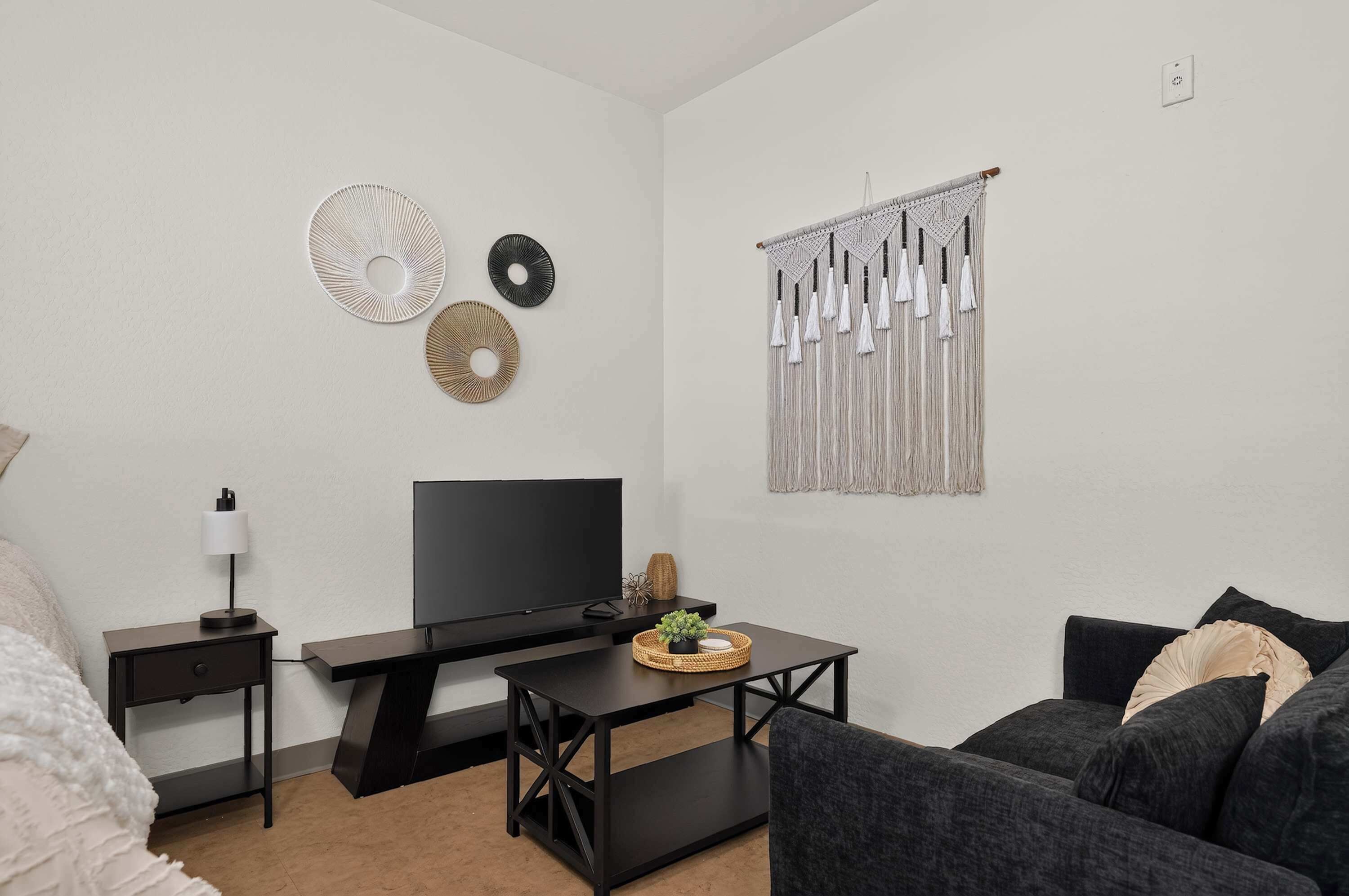 A modern living room with a flat-screen TV, a coffee table, and a couch.