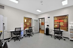A conference room with two desks, chairs, a whiteboard, and a door leading to another room. - Modern King Suite - Steps from UAT and near ASU (Tempe)