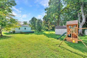 A backyard with a wooden play structure, a small shed, and a house. - Family Retreat with Pool & Playground (Roslyn)